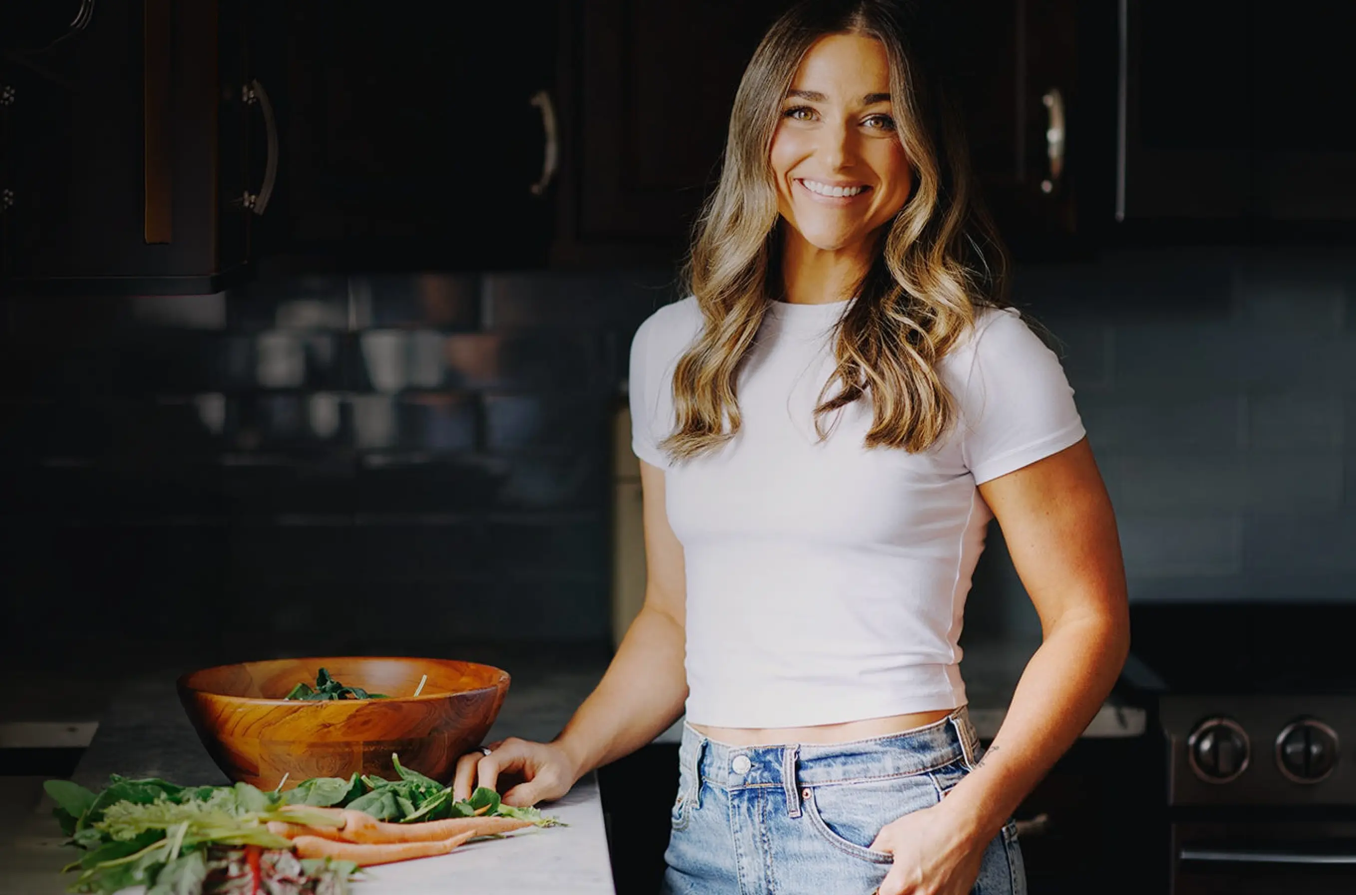 Dana Hartman, a fertility educator, preparing a salad in her kitchen